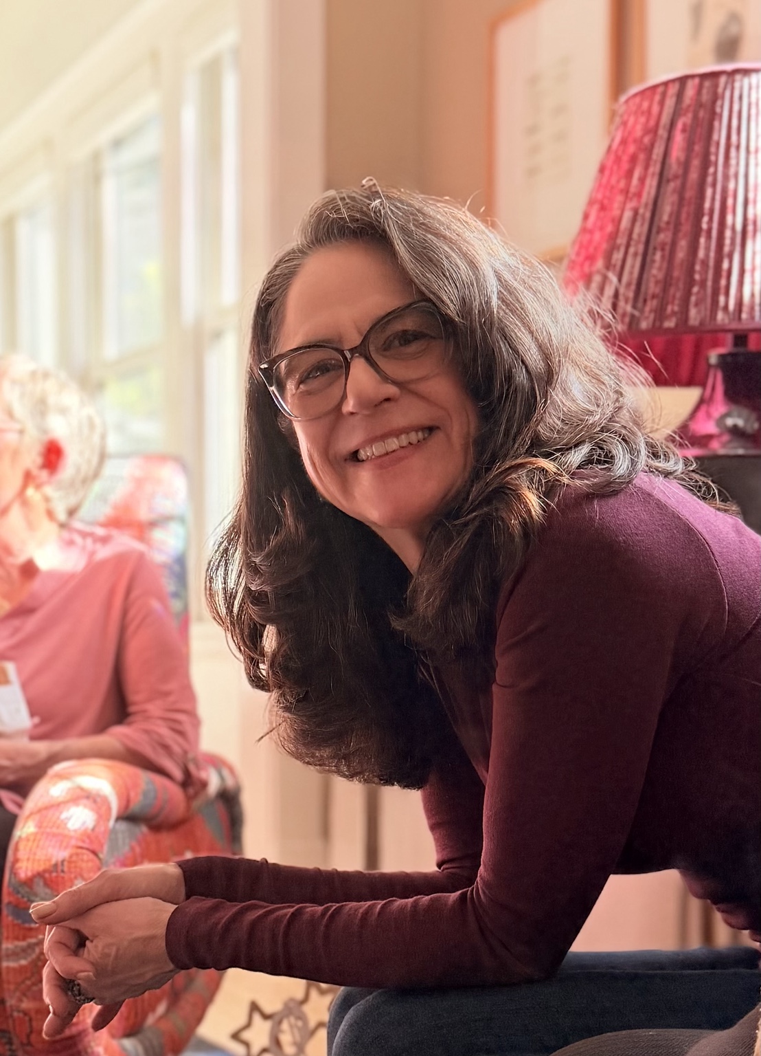 A candid photograph of author Anita Haddorff smiling in a wine-colored sweater